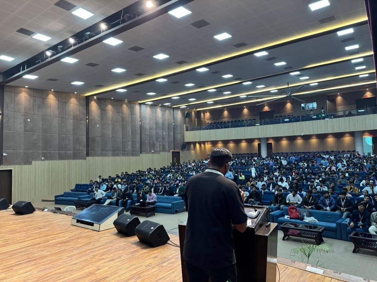 Viren Gajjar presenting from stage to a packed auditorium at a Google Developer Groups event