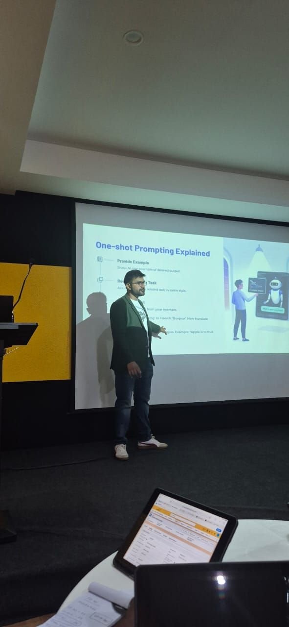 Viren Gajjar explaining one-shot prompting techniques from a lecture stage